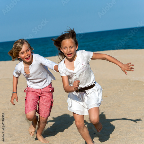 Photo: Boy chasing girl on beach. Boy chasing girl on beach.