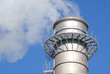 Industrial chimney releasing gasses in to a clear blue sky