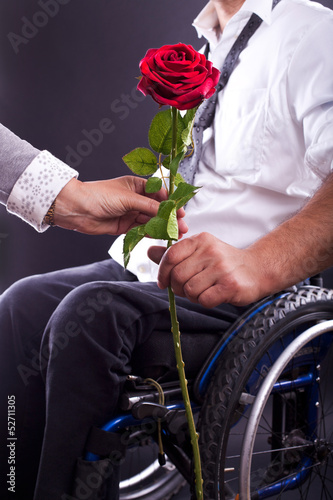 Photo: Rollstuhlfahrer übergibt eine Rose Rollstuhlfahrer übergibt eine Rose
