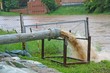 impressive exhaust flows into river rainwater and mud
