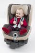 toddler in booster seat for a car in light background