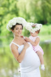 Pregnant mother and her daughter have fun outdoor