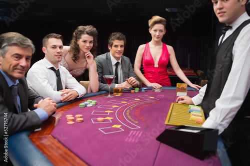 Photo: People sitting at the blackjack table smiling at the casino People sitting at the blackjack table smiling at the casino