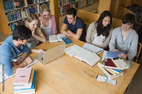 Photo: Students learning with laptop and tablet in a library Students learning with laptop and tablet in a library