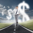 Photo: Businessman running on a road with dollars floating Businessman running on a road with dollars floating