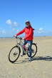 Radfahrerin am Strand