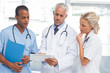 Three doctors using a tablet