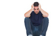 Sad man sitting on the floor while holding his head