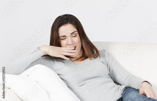 Photo: woman yawning on sofa woman yawning on sofa