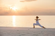 Caucasian woman practicing yoga at seashore