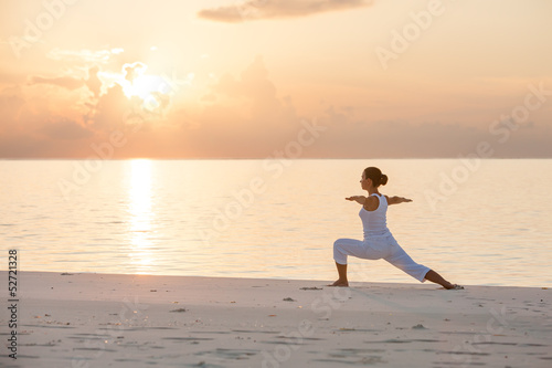 Photo: Caucasian woman practicing yoga at seashore Caucasian woman practicing yoga at seashore