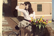 vintage pin-up with flowers on bike in old town