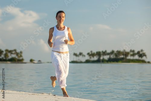 Photo: Caucasian woman jogging at seashore Caucasian woman jogging at seashore
