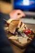 Half Eaten Sandwich On Wooden Plate