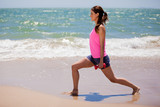 Cute girl exercising at the beach