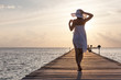 Caucasian woman takes rest at wooden pier to Indian ocean