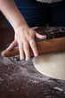 Hand on a rolling pin preparing pizza dough