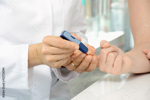 Photo: Apothekerin bestimmt Blutzuckerwert Apothekerin bestimmt Blutzuckerwert
