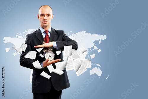 Photo: Business man holding alarmclock Business man holding alarmclock