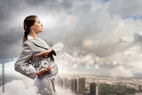 Photo: Businesswoman holding alarmclock Businesswoman holding alarmclock