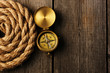 Antique compass and rope over wooden background