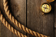Photo: Antique compass and rope over wooden background Antique compass and rope over wooden background