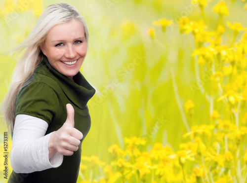 Photo: junge Frau im Blumenfeld mit Daumen hoch junge Frau im Blumenfeld mit Daumen hoch
