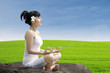 Beautiful girl exercise yoga on green field