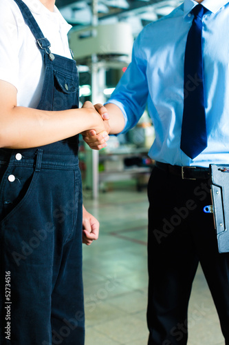 Photo: Worker and production manager in a factory Worker and production manager in a factory