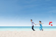 Running couple at beach wih balloons