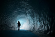 Human figure silhouette inside ice cave