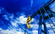 Oil and gas well detail profiled on blue sky with clouds