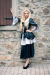 Photo: Beautiful girl wearing a medieval dress. Stone wall background. Beautiful girl wearing a medieval dress. Stone wall background.