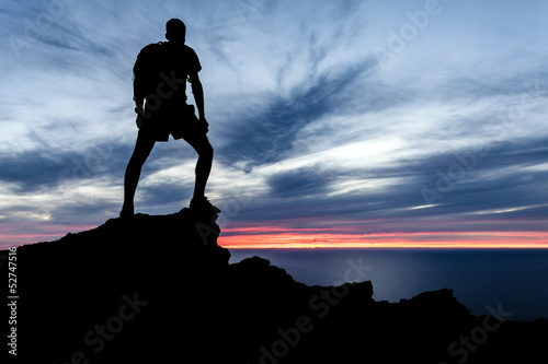 Photo: Man hiking silhouette in mountains, ocean and sunset Man hiking silhouette in mountains, ocean and sunset