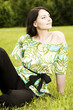 Foto: Beauty portrait of woman, sitting on a grass field Beauty portrait of woman, sitting on a grass field