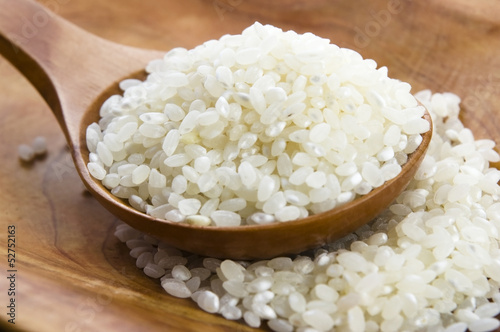 Photo: Rice in wooden spoon on kitchen table Rice in wooden spoon on kitchen table