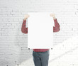 man holding blank poster