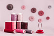 Sewing kit with buttons on pink background