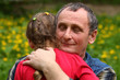 Grandfather hugging granddaughter with his eyes closed