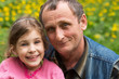 Grandfather hugging laughing granddaughter in nature.