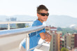 Portrait of smiling boy stands on balcony of hotel