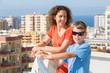 Mother and son on balcony of room at hotel on top floor