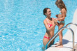 Photo: Mother helping her daughter to go to the pool. Mother helping her daughter to go to the pool.