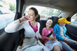 Mother, daughter and son in the back seat of a car