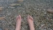 Footage of a Pair of feet in cool water