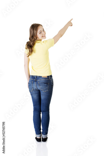 Photo: Happy , excited young woman pointing on copy space Happy , excited young woman pointing on copy space