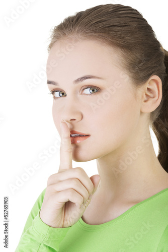 Photo: Hush be quiet woman isolated. Teen girl with finger on her lips. Hush be quiet woman isolated. Teen girl with finger on her lips.