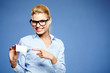 Businesswoman holding credit card. Isolated on blue