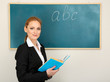 Portrait of teacher woman near chalkboard in classroom