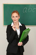 Photo: Portrait of teacher woman near chalkboard in classroom Portrait of teacher woman near chalkboard in classroom